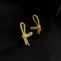 Asymmetrische Schleifen Ohrclips mit funkelndem Zirkon und poliertem Gold für ungepierzte Ohren. - Doppelschicht-Ohrclips - Asymmetrische Zirkonia Schleife