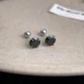 Detailed close-up of stainless steel black zirconia screw-back cartilage stud earrings. - Black