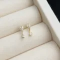Nahaufnahme minimalistischer 14K vergoldeter Zirkonia Ohrstecker mit feinem Detail. - Ausrufezeichen Stil / Gold