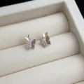 Detailansicht der filigranen 14K vergoldeten Schmetterlings-Ohrstecker mit Zirkonia-Steinen. - Violetter Schmetterling / Lila