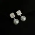 Wunderschöne Detailansicht platinbeschichteter Ohrclips mit Zirkonia und grauen Perlen. - Geometrisch Zirkonia Glasperle Clip-on / Silber