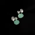 Detailaufnahme unregelmässiger silberner Ohrclips mit hellgrünem Anhänger für Damen. - Meeresblau Clip-on / Silber