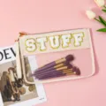 Detail shot of clear cosmetic bag with chenille letter STUFF, makeup brushes inside. - STUFF / Beige