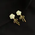 Elegante weiße emaillierte Kamelie Blume Ohrringe mit Kristall Schleife Detail Ansicht. - Doppelschichtige Clip-Ohrringe - Kamelie Schleife