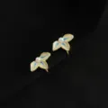 Nahaufnahme eleganter floraler Clip-Ohrringe mit weißen Blütenblättern und Perlenmitte. - Doppelschichtige Clip-Ohrringe - Drei-Blatt-Blume