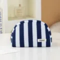 Striped cosmetic bag detail shot showing blue and white pattern and zipper closure for travel. - Blue and White Stripes