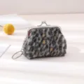 Detail shot of the 3-inch plush leopard print coin purse featuring metal kiss-lock and ring. - Black