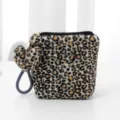 Leopard print plush cosmetic bag close-up showing soft texture and heart pendant. - Black