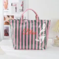 Pink and green striped PVC tote bag detail featuring front Bliss lettering and glossy texture. - Striped Green Pink