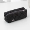 Black quilted pencil case detail, diamond lattice texture with sweet bow embroidery. - Black