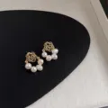 Detaillierte Nahaufnahme von eleganten vergoldeten Rosen- und Perlenohrringen im Display. - Rosenblüte Perle Stil (B-531)