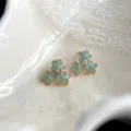 Nahaufnahme Detailansicht von mintgrünen Blumen Ohrringen mit filigranem Goldrand Design. - Osmanthus-Stil (4429)