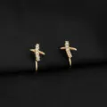 Detailansicht vergoldeter Kreuz-Ohrclips mit funkelnden Zirkoniasteinen auf schwarzem Stoff. - Gekreuzter Kreuzstil