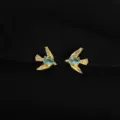 Detailaufnahme vergoldeter Schwalben-Ohrclips mit blauen Steinen, schmerzfreies Design. - Strass Vogel