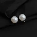 Nahaufnahme Detail von weissen Perlen Clip Ohrringen mit goldener Hardware auf dunklem Hintergrund. - Integrierter Ohrclip mit weißer Glasperle / 12mm / Weiß