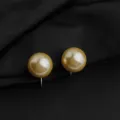 Nahaufnahme von goldenen Clip-Perlenohrringen, elegante Detailansicht auf schwarzem Stoff. - Goldene Glasperle Ohrclip / 14mm / Gold