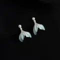 Exquisite detail shot of minimalist mint blue fish tail earrings with delicate pearl accents. - Double Layer Clip-On Earrings / Mermaid Skirt