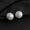 Detailansicht eleganter runder Clip-Ohrringe mit satinierter Oberfläche auf schwarzem Stoff. - Gebürsteter Kugelohrclip / 16mm / Silber