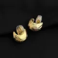 Detailansicht golden strukturierter Clip-Ohrringe mit bequemen Silikonkissen für ungebohrte Ohren. - Texturierter Goldbohnen-Stil