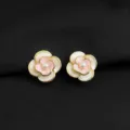 Nahaufnahme von eleganten doppelten Kamelien-Ohrringen mit Goldrand und Perlendetail. - Zweifarbiger Rosen-Stil