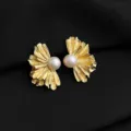 Goldene Fächer Perle Clip Ohrringe Detailansicht mit exquisiter Metall Textur und Glanz. - Süßwasserperlen-Gänseblümchen-Stil