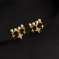Nahaufnahme von vergoldeten doppelten Ohrklemmen mit Perlen und funkelnden Sternen-Anhängern. - Zirkonia Stern Stil
