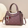 Elegant purple quilted leather handbag featuring a stylish cherry and pearl pendant accessory. - Purple