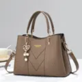 Brown women handbag with top handle, crossbody strap, and chic heart pearl pendant charm. - Khaki
