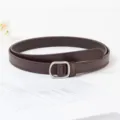 Vue détaillée de la fine ceinture en cuir marron minimaliste pour femmes avec boucle argentée. - 1,8 cm de large 105 cm de long / Café