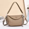 Detailed view of stylish brown leather shoulder bag with chic metal tassel and strap design. - Khaki