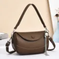 Brown leather shoulder bag detailed view, elegant curved flap crossbody handbag with chic tassel. - Coffee