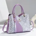 Detailed view of fashionable purple embroidered women shoulder handbag with elegant tassel charm. - Brocade Color-Block Purple