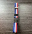 Vista detallada del cinturón elástico con un diseño de rayas y hebilla de plástico. - Azul Blanco Rojo