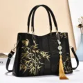 Chinese style black leather handbag with golden bamboo pattern, elegant tassel pendant. - Silk Brocade — Black Gold Bamboo
