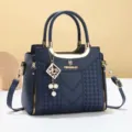 Elegant women's blue PU leather handbag with metal handle, embroidery, and stylish pearl charm. - Stitched Style - Blue
