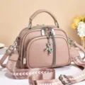 Pink leather crossbody bag with wide strap and cute balloon dog pendant for women. - Cartoon Zipper / Pink