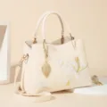 Elegant beige women handbag with delicate floral embroidery and leaf pendant, stylish shoulder bag. - Peony - Beige