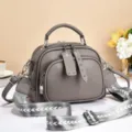 Grey women crossbody bag with wide strap and multi zipper compartments for daily commute. - Rivet Zipper / Gray