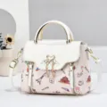 Detailed view of women fashion casual handbag with chic print and elegant swan metal buckle. - Off White