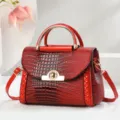 Borsa a tracolla rossa in pelle con motivo coccodrillo, dettagli dorati ed eleganti finiture. - Coccodrillo / Rosso Vino