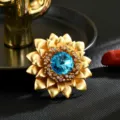 Impresionante broche flor dorada gran cristal azul central elegante accesorio joyería vista principal - Forma Flor