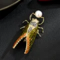 Elegante broche de cigarra dorada con perla de agua dulce y pedrería para accesorios de mujer. - Blanco