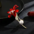 Elegante broche de flor de lirio rojo con baño de oro, circonitas brillantes y perla. - Circonita con centro blanco
