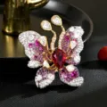 Wunderschöne Schmetterlingsbrosche mit funkelnden Zirkoniasteinen und rotem Hauptstein. - Schmetterling Brosche