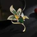 Hermosa broche de hoja de circonita cúbica de color corsé dorado elegante para abrigo. - Verde