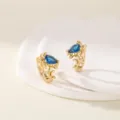 Primo piano sui dettagli degli orecchini a cerchio tartaruga in cristallo blu dorato raffinato. - Tartaruga Marina(ek283) / Oro