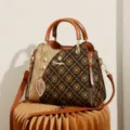 Stylish brown monogram women handbag with top handles, crossbody strap and elegant leaf charm. - Circle-Ochre