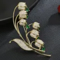 Elegante broche de lirio de los valles bañado en oro con circonitas y piedras verdes. - Verde