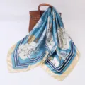 Detail shot of a blue floral silk square scarf draped gracefully over a luxury leather handbag. - 90cm / Rose Blue