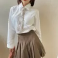 Detail shot of a Japanese JK uniform set with white shirt, plaid pre-tied necktie, and skirt. - Khaki Plaid Tie 1